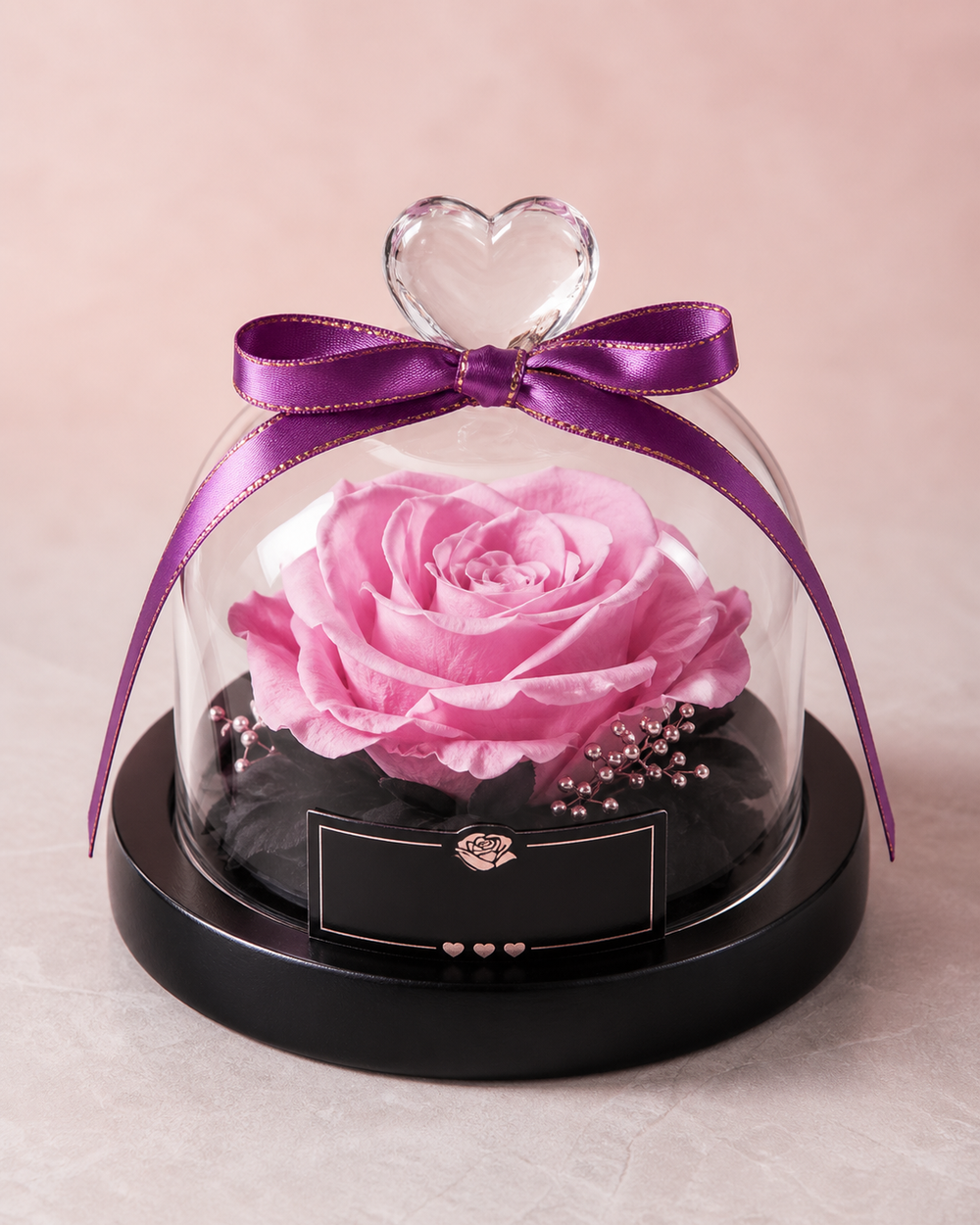 Preserved rose under a glass dome with a purple ribbon